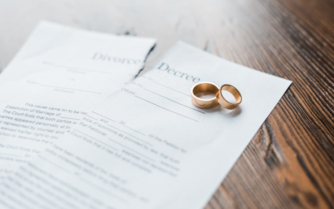 A torn divorce decree with engagement rings on top of it.