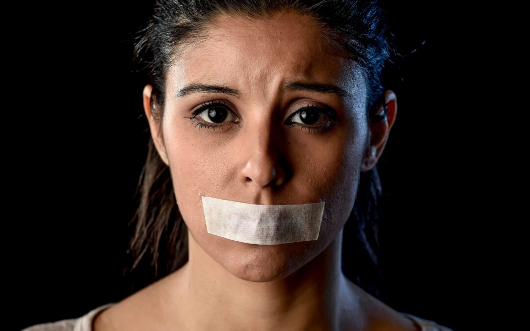 The image of a young woman with her mouth sealed with adhesive tape.